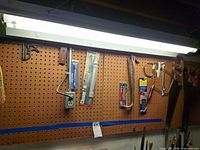 Overall pegboard view showing saws, wrenches, door closer, level