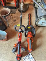 Overall view of string trimmer, hedge trimmer, charger and battery