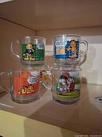 Four Garfield mugs stacked showing different comic scenes
