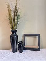 Tall metal vase with faux plant, small ceramic vase, square wall shelf