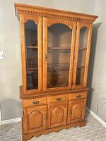 Full view of cabinet showing glass upper doors, drawers and lower doors