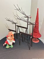 Front view showing three metal reindeer, red glitter cone tree and gnome