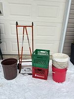 overall view of hand truck, crates, pails and bucket