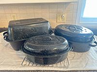 Three enamel roasters with lids and wire rack group shot