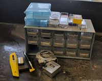 Front view of parts cabinet with drawers, fastener boxes, tape measures, utility knife