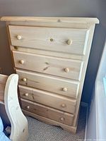 Front view of 5-drawer pine dresser showing knobs and scalloped base