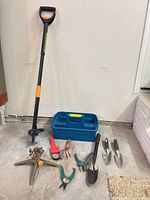 Full lot overview showing weed puller, sprinkler, hand tools and caddy