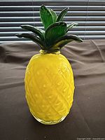 Full view of yellow glass pineapple with green leaves