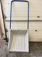 Full view of snow pusher showing bucket and handle