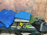 All items laid out: tarps, ground mat, 3 flashlights, duffle bag