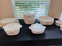 Group shot of CorningWare casseroles, square dish, petite pans and ramekins with lids
