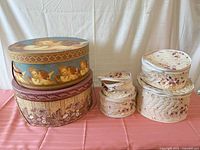 Two hat boxes stacked beside four quilted dish cases