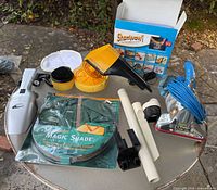 Overview of entire lot on table showing ShamWow box, Magic Shade package, two handheld vacuums, buffer tool, Royal appliance, attachments