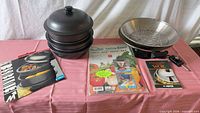 Full lot showing steamer stack, electric wok with rack and probe, sealed cutting board, manuals