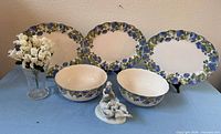 Group shot showing all platters, bowls, vase with flowers, figurine