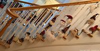 Full staircase view showing approximately nineteen Santa head ornaments hanging on spindles