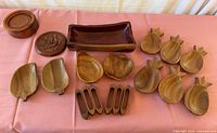 Full set laid out showing all wooden plates, trays, bowls, napkin rings, container and coasters