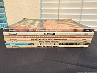 Stack of seven Sunset soft-cover reference books showing spines and titles