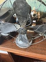 Front view showing fan blades, GE badge, wire cage, base