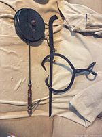 All three fireplace tools laid out: tongs, log hook, perforated pan roaster