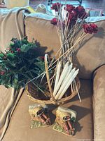All items arranged on sofa: artificial flowers, wicker basket, taper candles, ceramic bookends