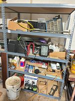 Overall view of metal shelving unit and assorted contents