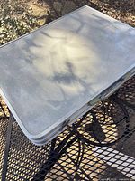 Table folded into briefcase form on patio furniture