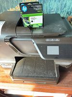 Front view of HP Officejet Pro 8600 printer with boxed 950XL cartridge on scanner lid