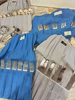 Overview of flatware rolls with forks, knives, spoons, serving pieces