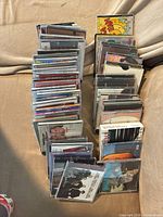 Overall view of stacked CDs showing quantity and varied cases