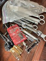 Pile of assorted hand tools showing wrenches, screwdrivers, ratchet, pliers, hex keys