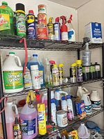 Full view of three upper shelves showing assorted gallon jugs, spray cans, quart can, bottles