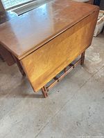 Table with one leaf dropped showing veneer top and rattan frame