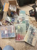 Assorted plastic organizers and bags of beads on floor