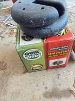 Box showing Quik Shade Universal Weight Plates with two plates stacked on top