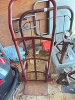 Full view of red steel hand truck in storage area
