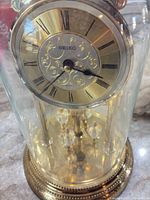 Front view of Seiko gold-tone mantel clock under glass dome