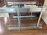 Front view of two-tier stainless steel pull-out organizer on tabletop