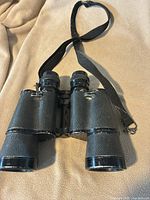 Front view showing objectives, body covering and strap