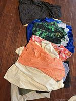 Pile of mixed women’s garments on wood floor