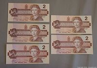 Five 1986 Canadian $2 notes laid out