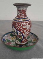 Vase standing in saucer showing pattern and colours