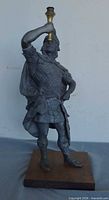 Front view of metal Roman warrior figurine on wood base
