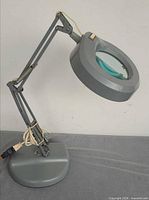 Full view of gray magnifying lamp, arm partially extended