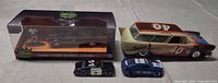 Group shot of boxed Batmobile set, stock car, and two loose police cars