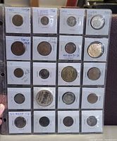 Front side of 20 world coins in flips inside binder sheet