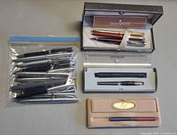 Overview of lot showing zip bag of pens, presentation box with three pens, travel case, Laque box