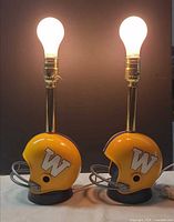 Front view of both helmet lamps lit, showing W logo, facemasks and overall design