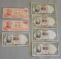 Group shot of all seven banknotes showing denominations, colours and wear.