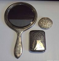 Front view of hand mirror, pill box, match safe